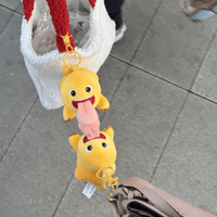 Thumbnail for A plush dragon keychain doll with a big tongue, in yellow and pink colors, attached to a metal keychain.